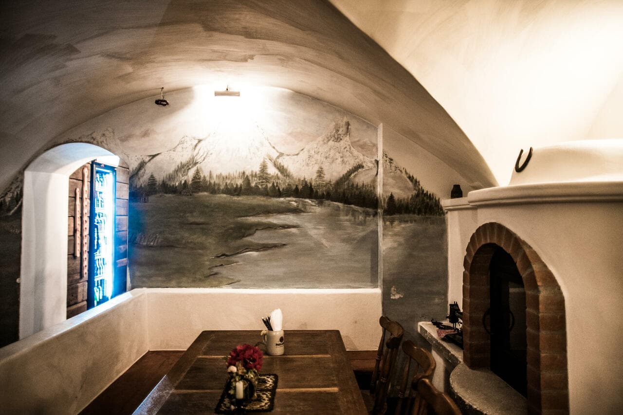 Kaminstube kamina ja Alpide seinamaaliga